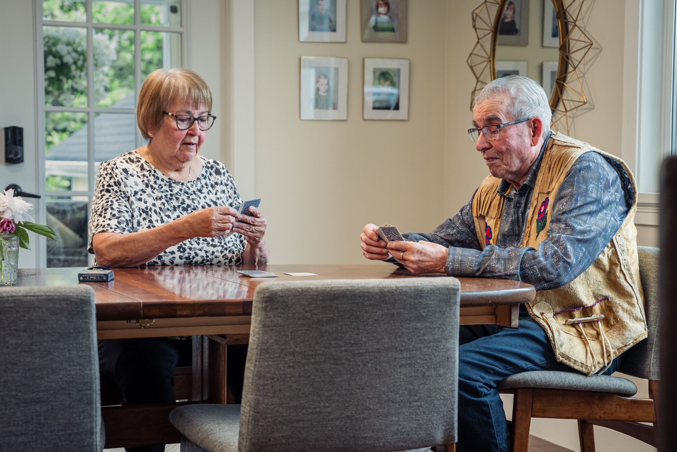 An elderly couple enjoying a quiet card game at home, fostering connection and leisure.
